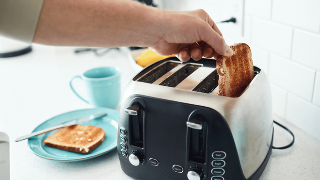 person taking a slice of toast out of a toaster